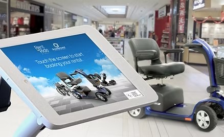 Rent A Ride self-serve rental kiosk beside a Scootaround mobility scooter